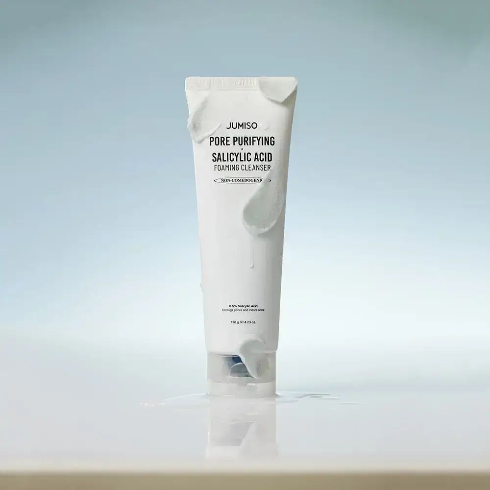 Witte tube met schuim. Opschrift: JUMISO Pore Purifying Salicylic Acid Foaming Cleanser. In water.