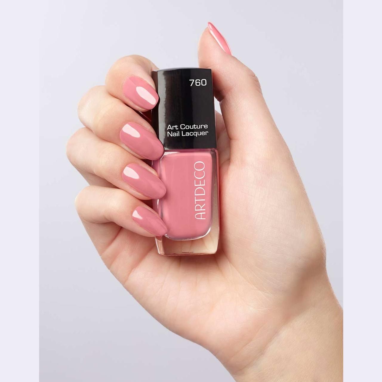 Hand houdt Artdeco Art Couture nagellak vast. Gelakte nagels in roze. Zwarte dop met opschrift 760.