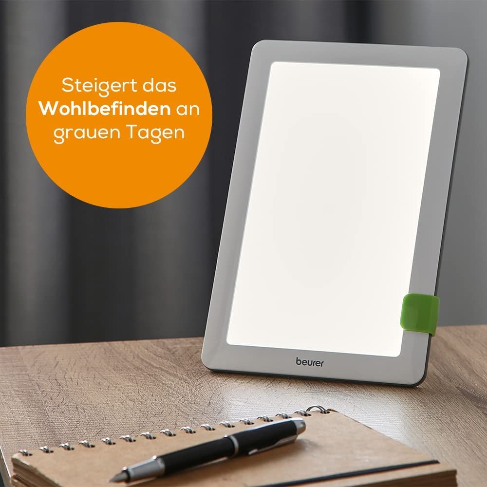 Daglichtlamp op tafel. Tekst: Verbetert het welzijn op grijze dagen. Merk: beurer.