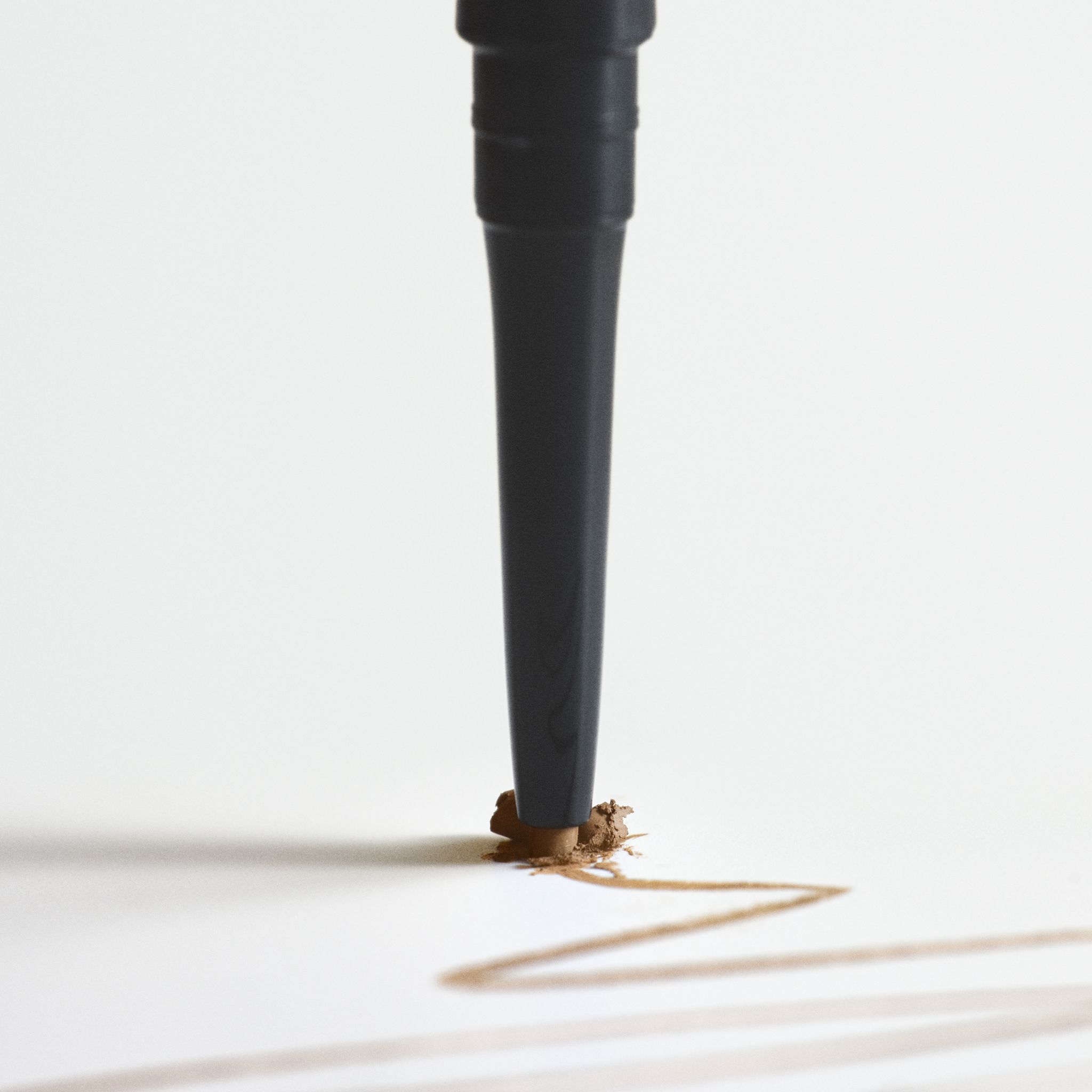 Pointe du RevitaLash Hi-Def Brow Pencil Soft Brown traçant une ligne.