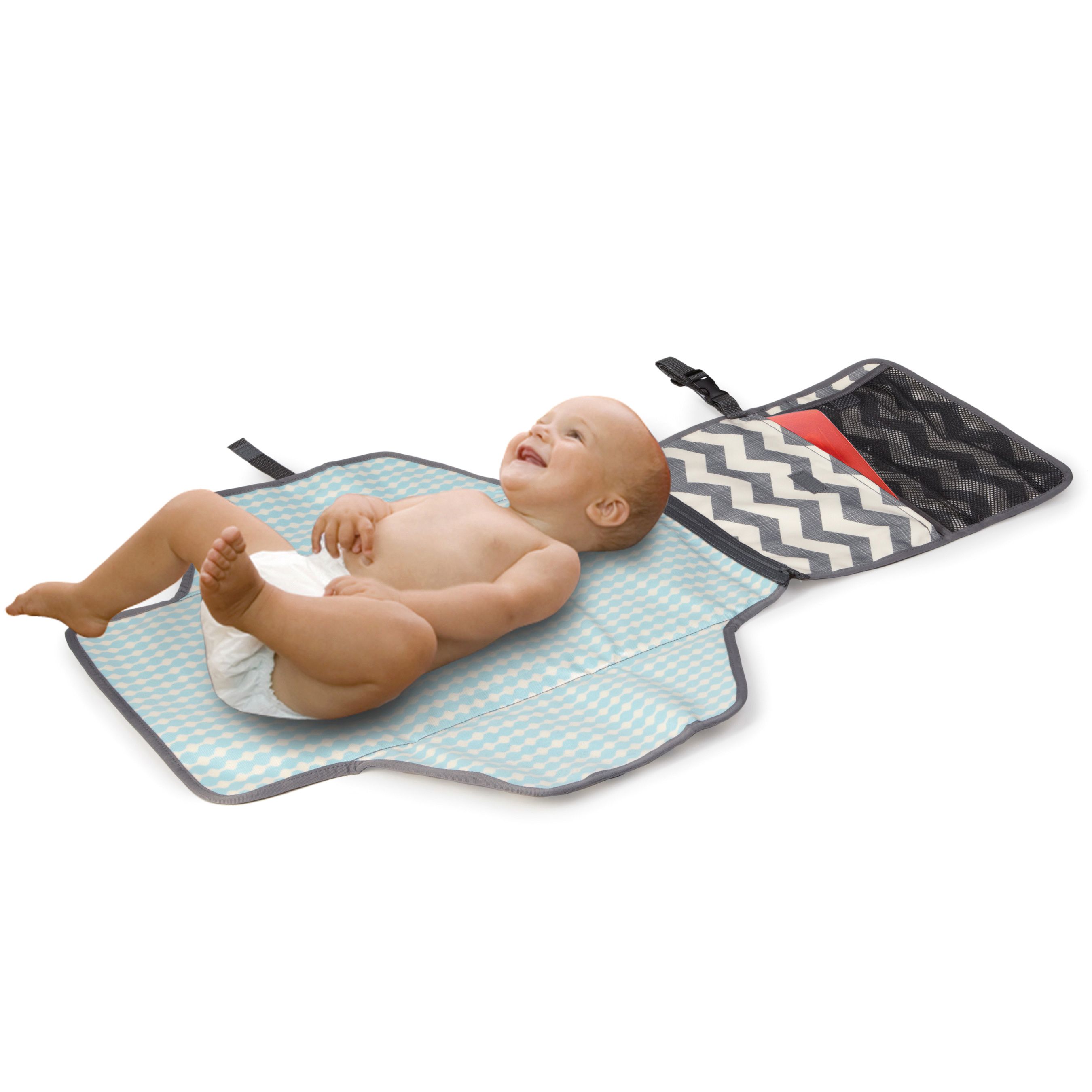 Verschoonmat met baby. Lichtblauw patroon, grijze rand. Open vakken. Baby ligt op de mat.