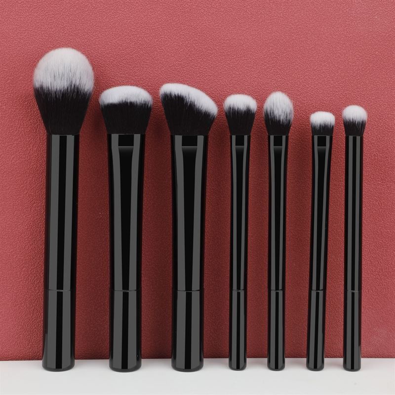 Ensemble de sept pinceaux de maquillage noirs avec poils blancs. Différentes formes et tailles.