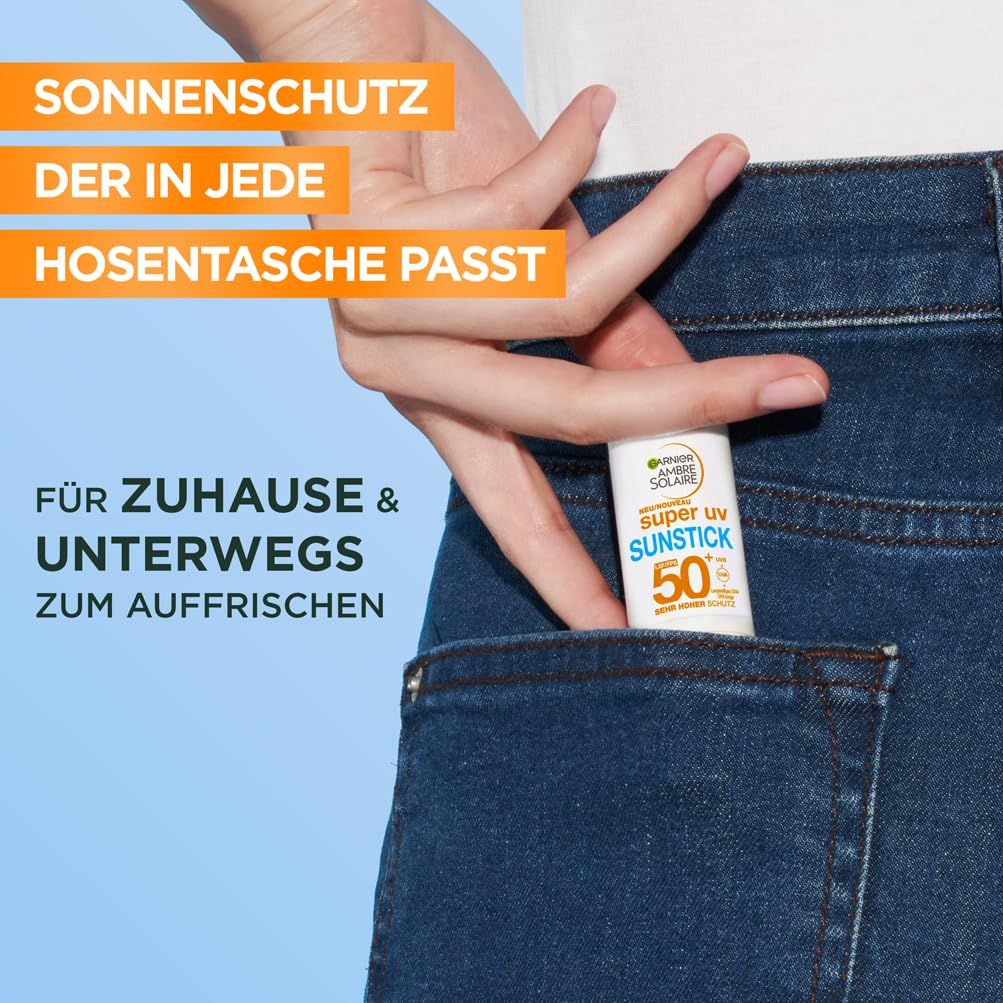 Main plaçant le stick solaire Garnier Ambre Solaire Super UV dans une poche de jean. Le bâton est blanc avec lettrage bleu et vert. Texte: Protection solaire.