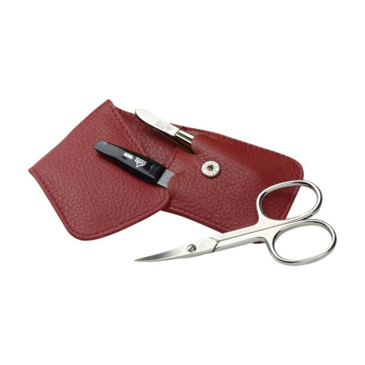 Étui rouge en cuir avec ciseaux, pince à épiler et coupe-ongles. Fermeture à bouton-pression. Ciseaux nickelés.