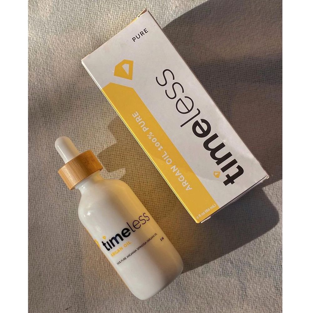 Productfles en verpakking. Witte fles met houten dop. Gele verpakking met TIMELESS-logo en productinformatie.