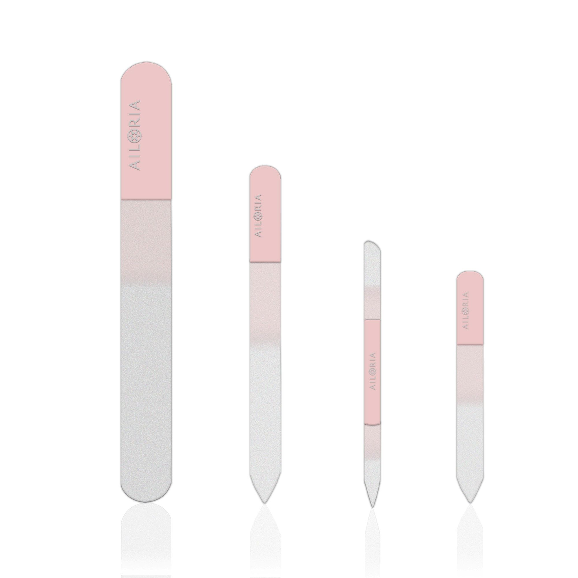 Quatre limes à ongles en verre de différentes tailles. Poignées roses, logo AILORIA. Surfaces de limage transparentes.