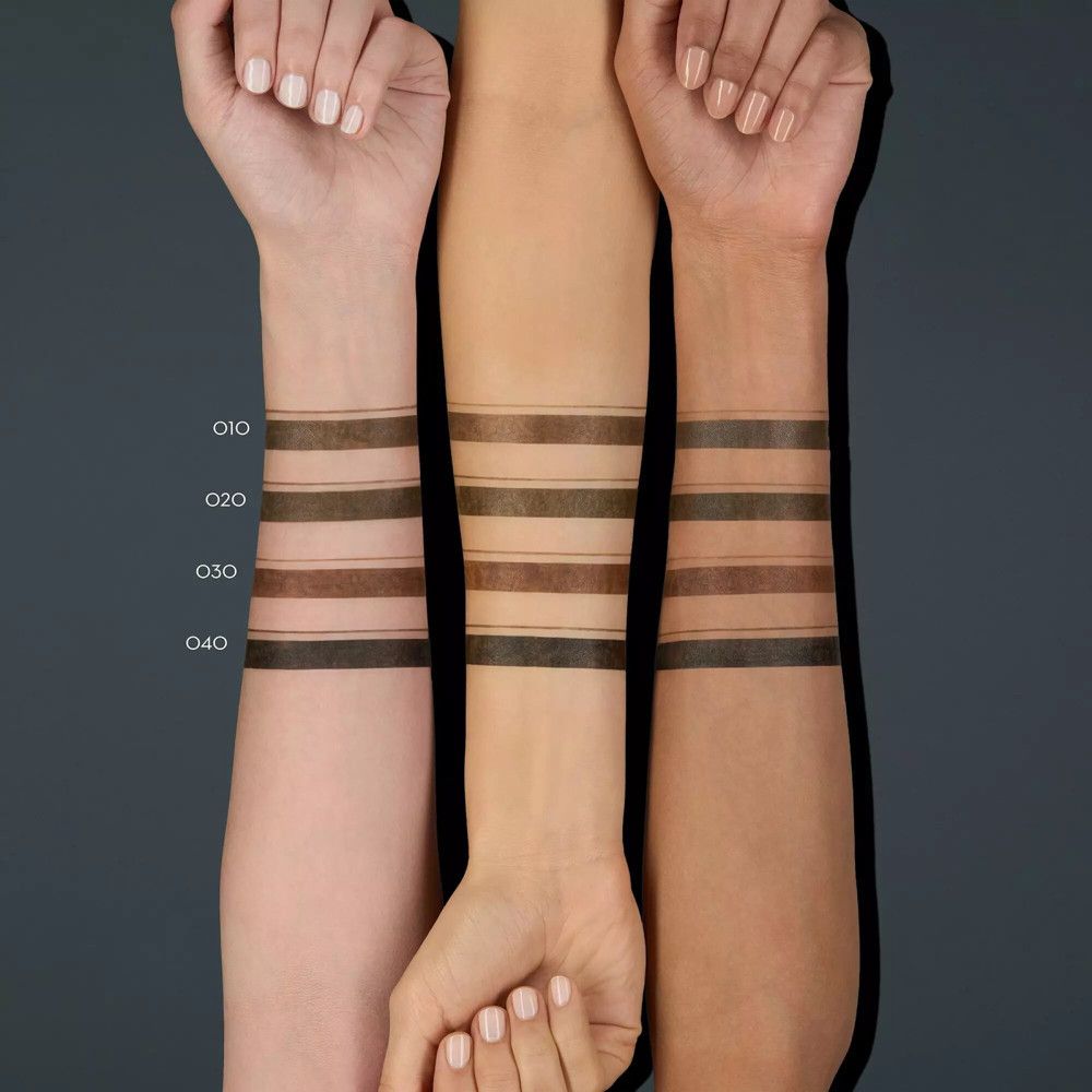 Bras avec échantillons de couleurs du crayon à sourcils. Différents tons de peau. Numéros: 010, 020, 030, 040.