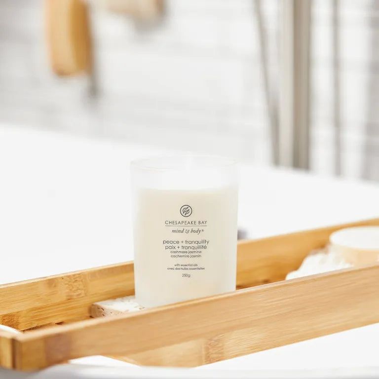Bougie Chesapeake Bay, mind & body, peace + tranquility. Sur plateau en bois dans salle de bain. Avec texte.