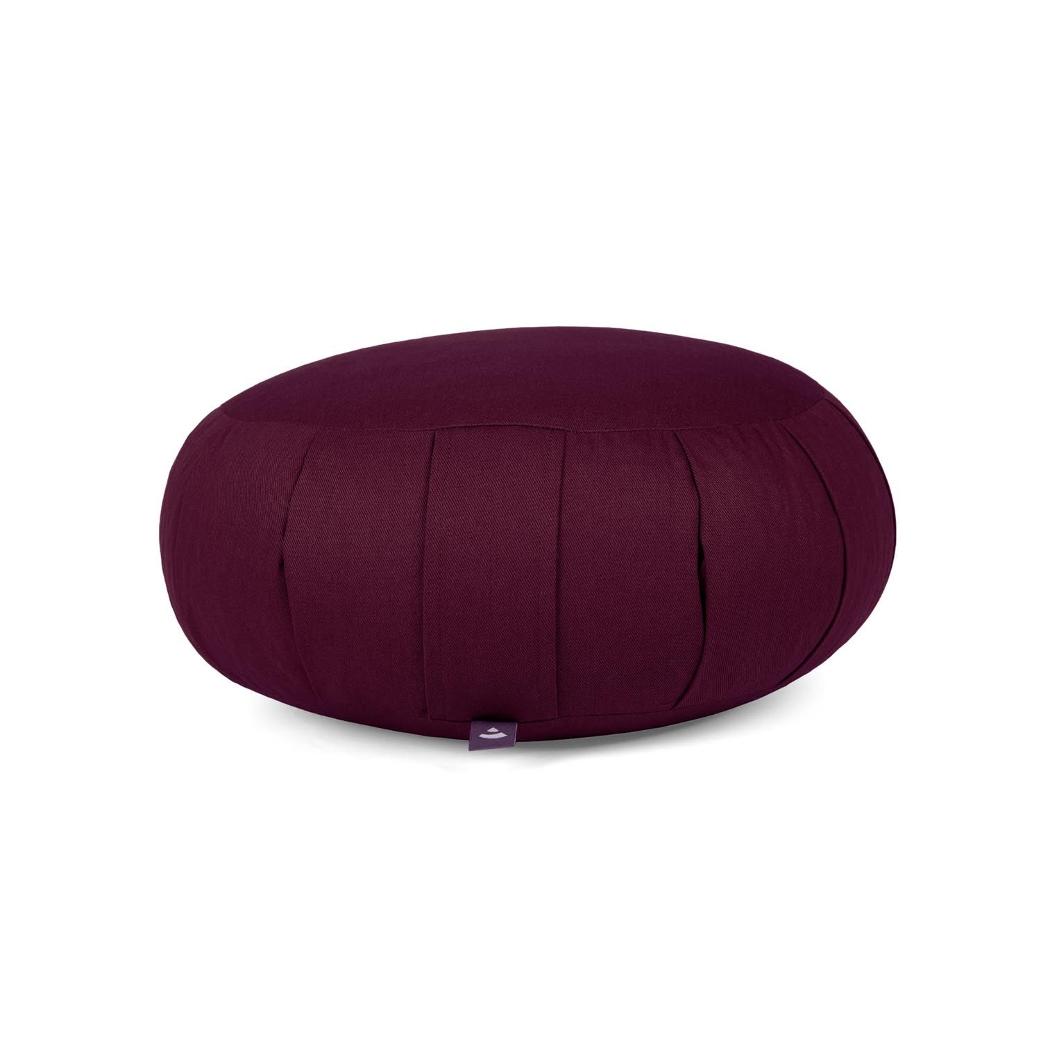 Coussin de méditation ZAFU bordeaux. Rond, avec plis et étiquette. Gros plan sur fond clair.