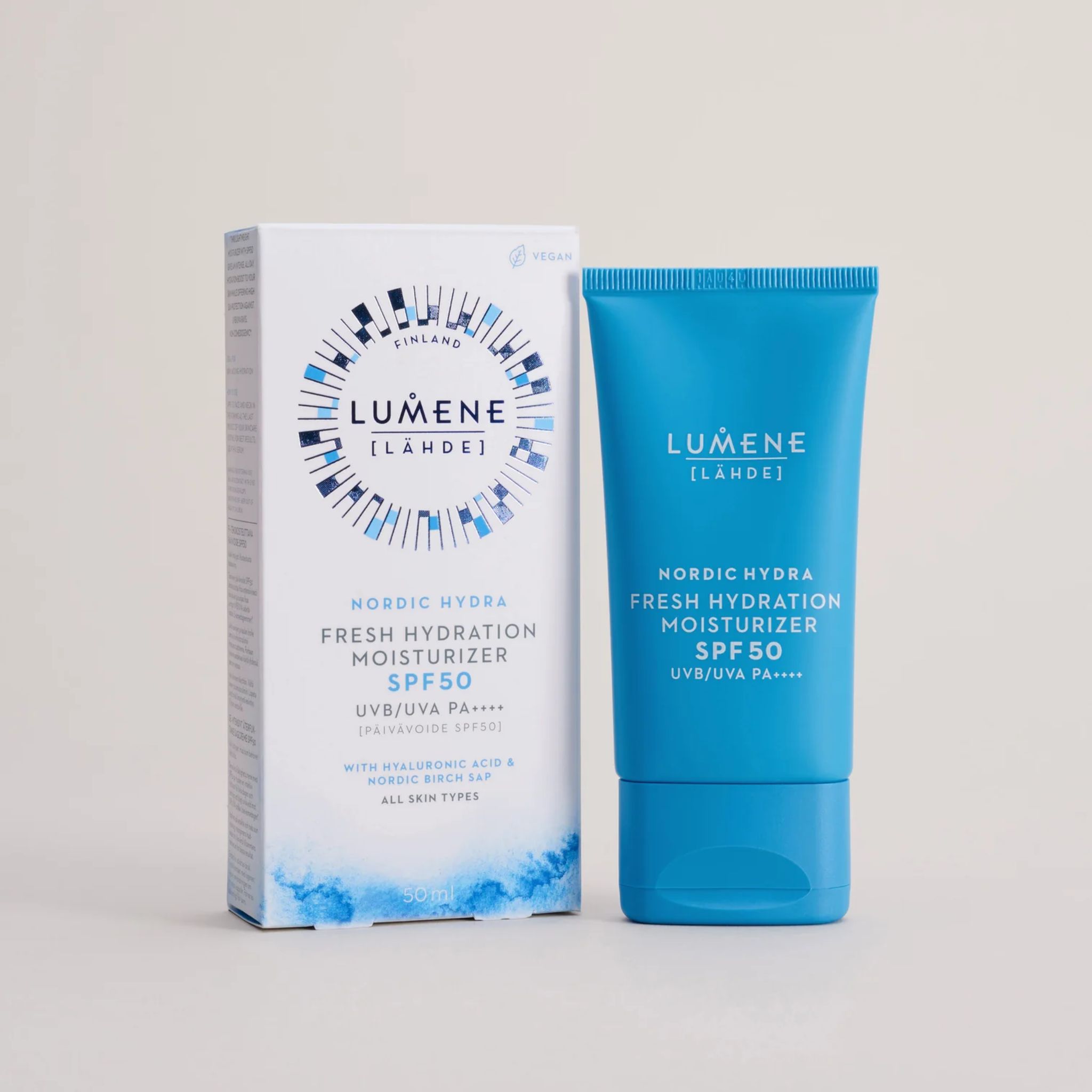 Emballage et tube. Emballage: blanc avec design bleu. Tube: bleu clair, texte: LUMENE [LÄHDE], Nordic Hydra Moisturizer SPF50.