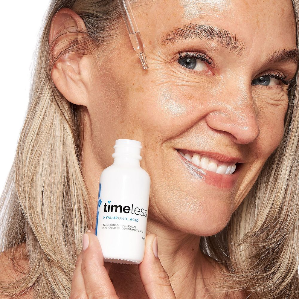 Femme tenant un flacon avec pipette. Sur le flacon, on lit "timeless hyaluronic acid".