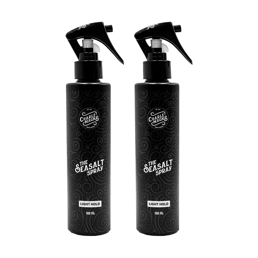 Twee zwarte spuitflessen "The Seasalt Spray" met zwarte pompkop. "Light Hold" en "200 ml" staan op de flessen.