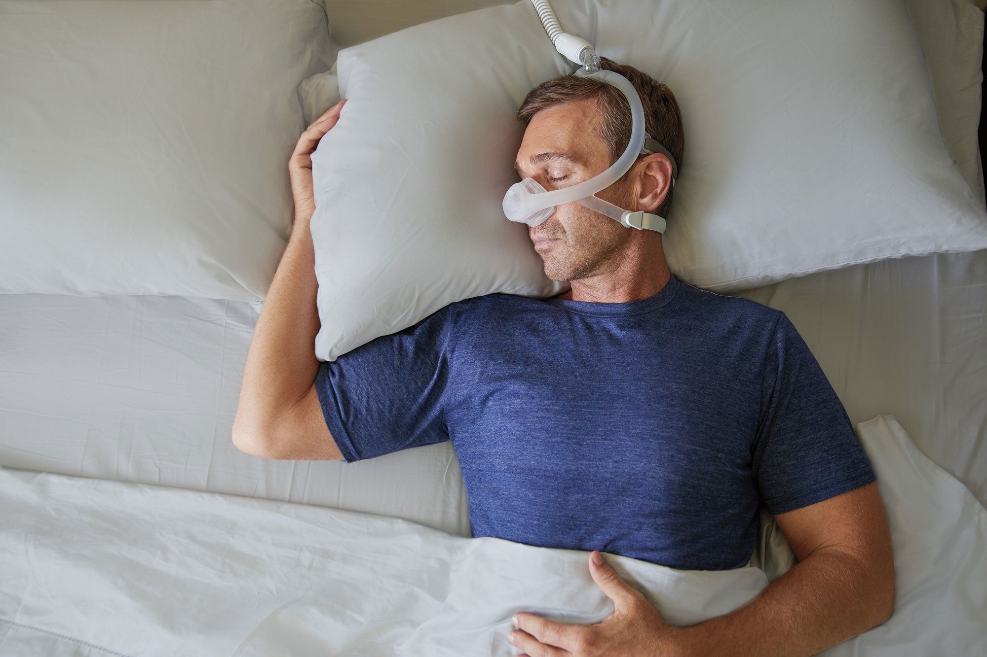 Man slaapt met neusmasker en slang.
