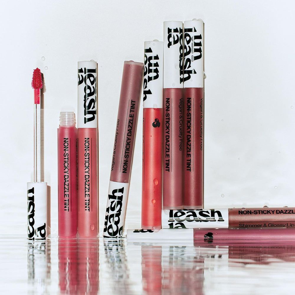 Plusieurs tubes de brillant à lèvres avec bouchon blanc et lettrage noir. Inscription : Non-Sticky Dazzle Tint.
