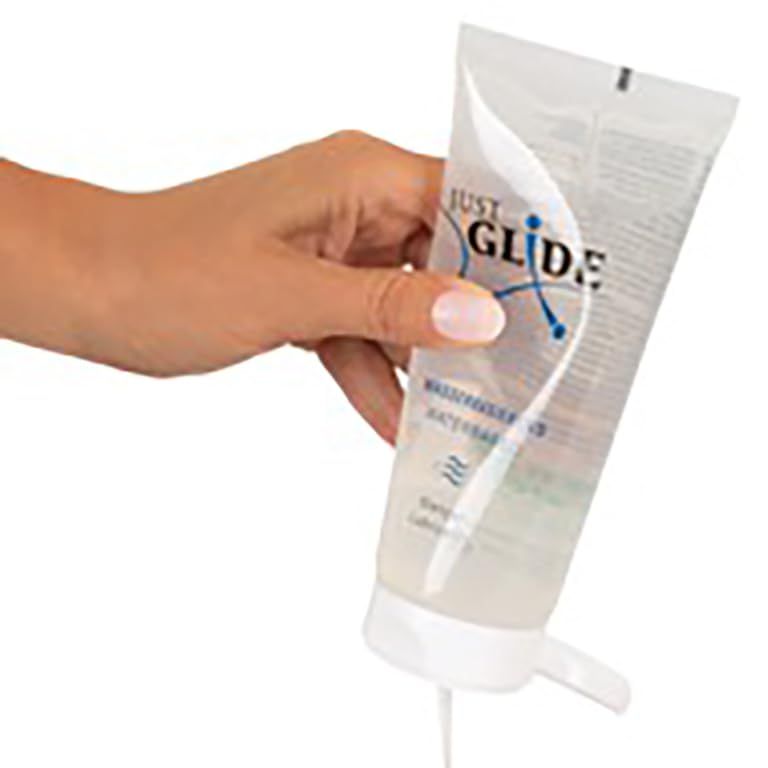 Hand die op de pompdos van een fles met heldere glijgell drukt.