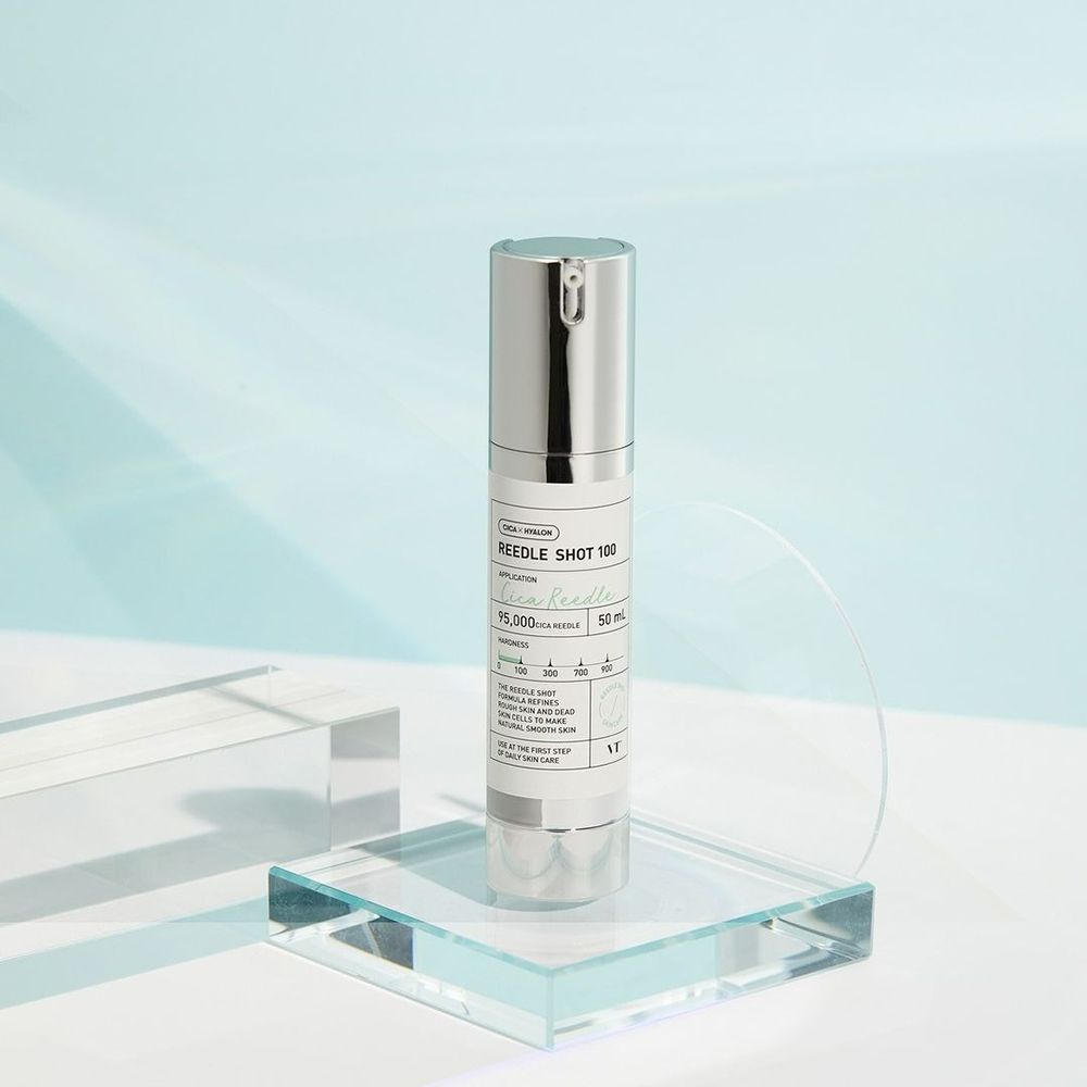 Flacon de sérum avec bouchon argenté sur bloc de verre. Inscription : REEDLE SHOT 100, 50 ml.