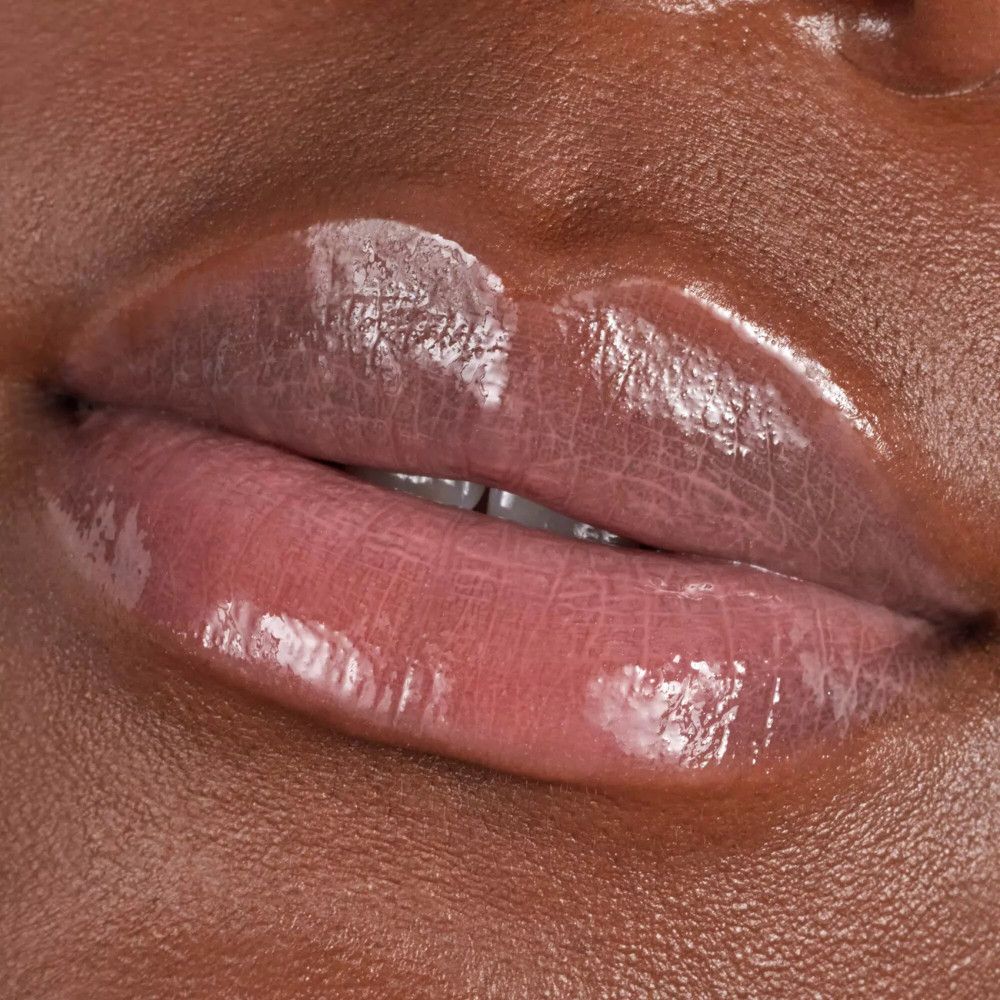 Close-up van lippen met glanzende lipgloss. Donkere huid. Open mond.