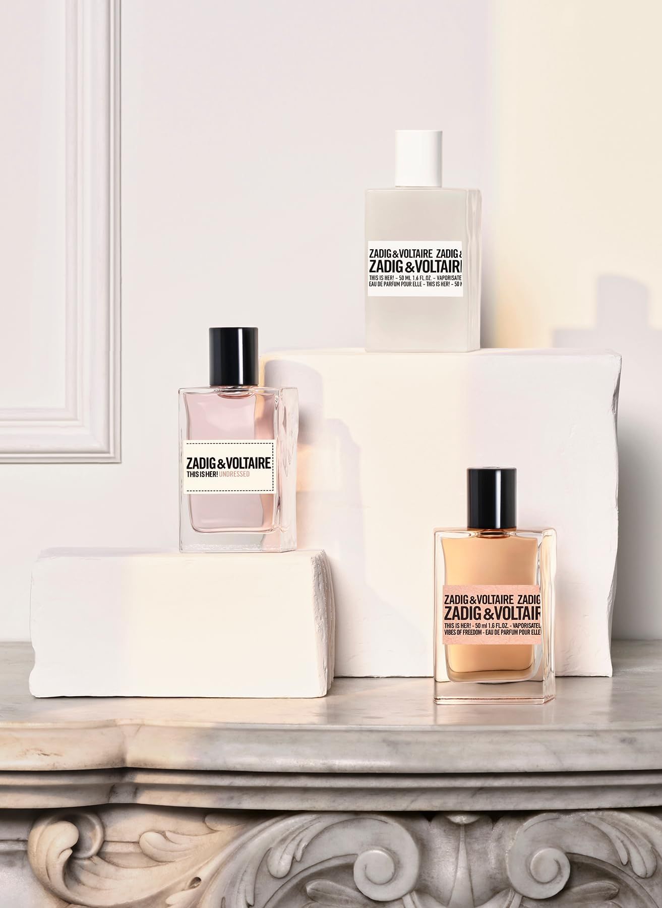 Drie Zadig & Voltaire This Is Her! Undressed Eau de Parfum flacons. Op sokkels. Verschillende kleuren.