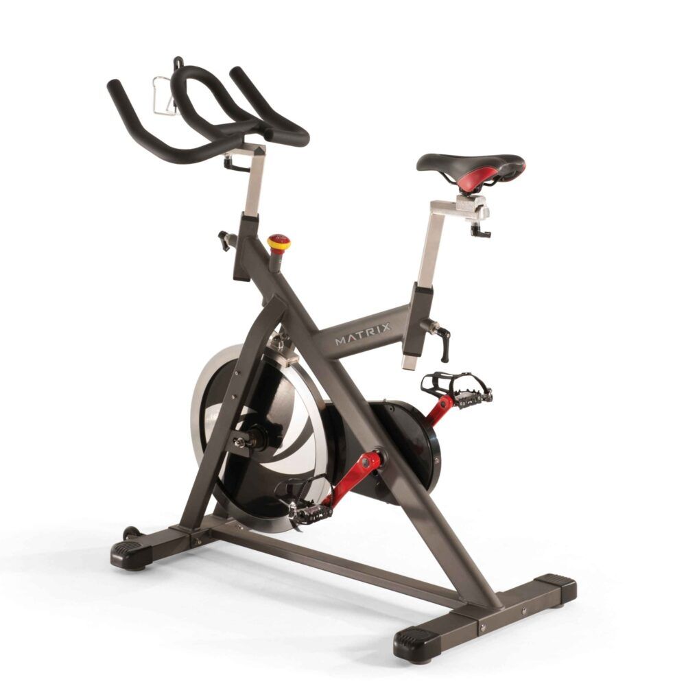 Indoor Cycle. Grijs frame, zwart stuur, rood zadel. Rood detail op de pedalen. MATRIX-logo.
