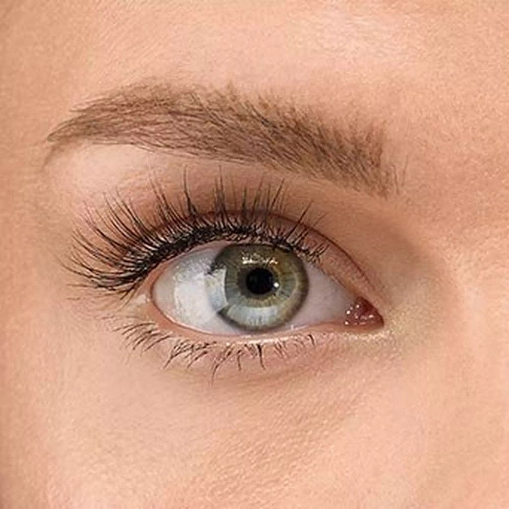 Close-up van een oog met valse wimpers. Het oog is groen-blauw. De wimpers zijn zwart en verlengen het oog.