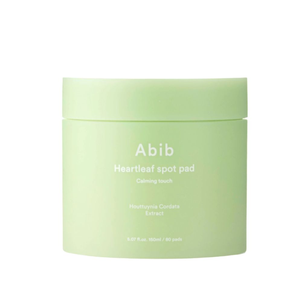 Abib Heartleaf Spot Pad Calming Touch: een ronde, groene pot met witte belettering, licht schuin op een witte achtergrond.