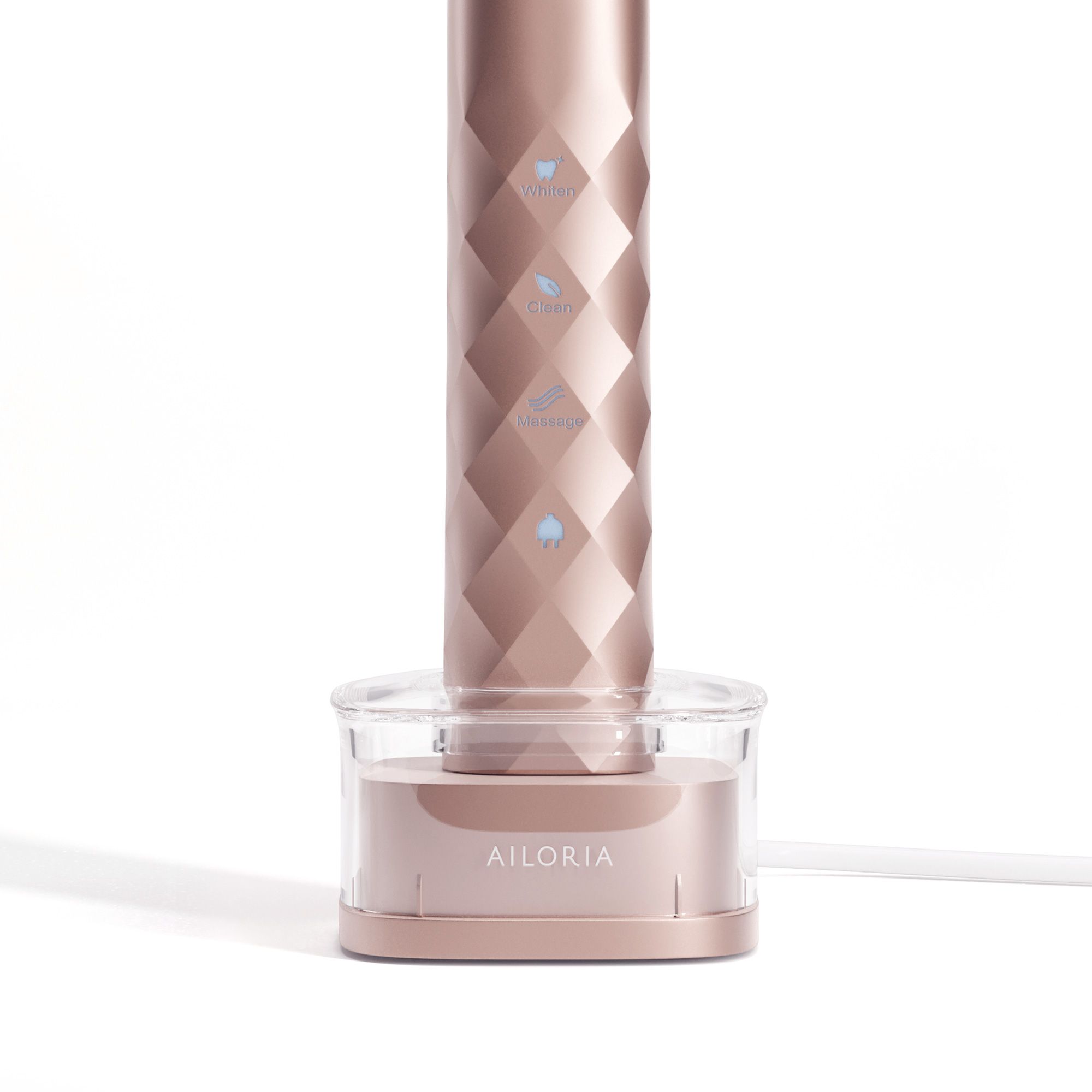 Station de charge inductive. Boîtier rose doré avec insert transparent. Logo AILORIA. Appareil en charge.