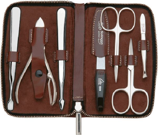 Manicure set in bruine etui: 7 roestvrijstalen instrumenten, waaronder nagelriemschaar, pincet en nagelvijl.