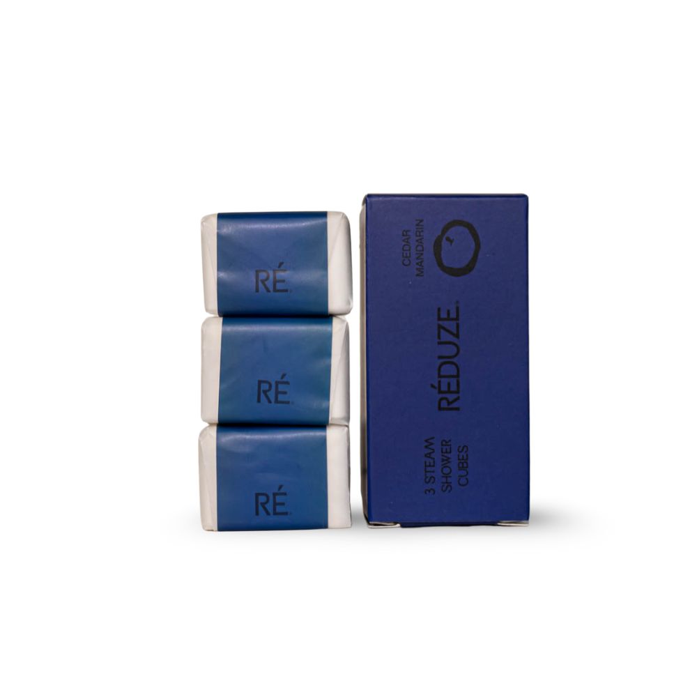 3 douchecubes en een doos. Opschrift: RÉ, 3 Steam Shower Cubes, Cedar Mandarin.