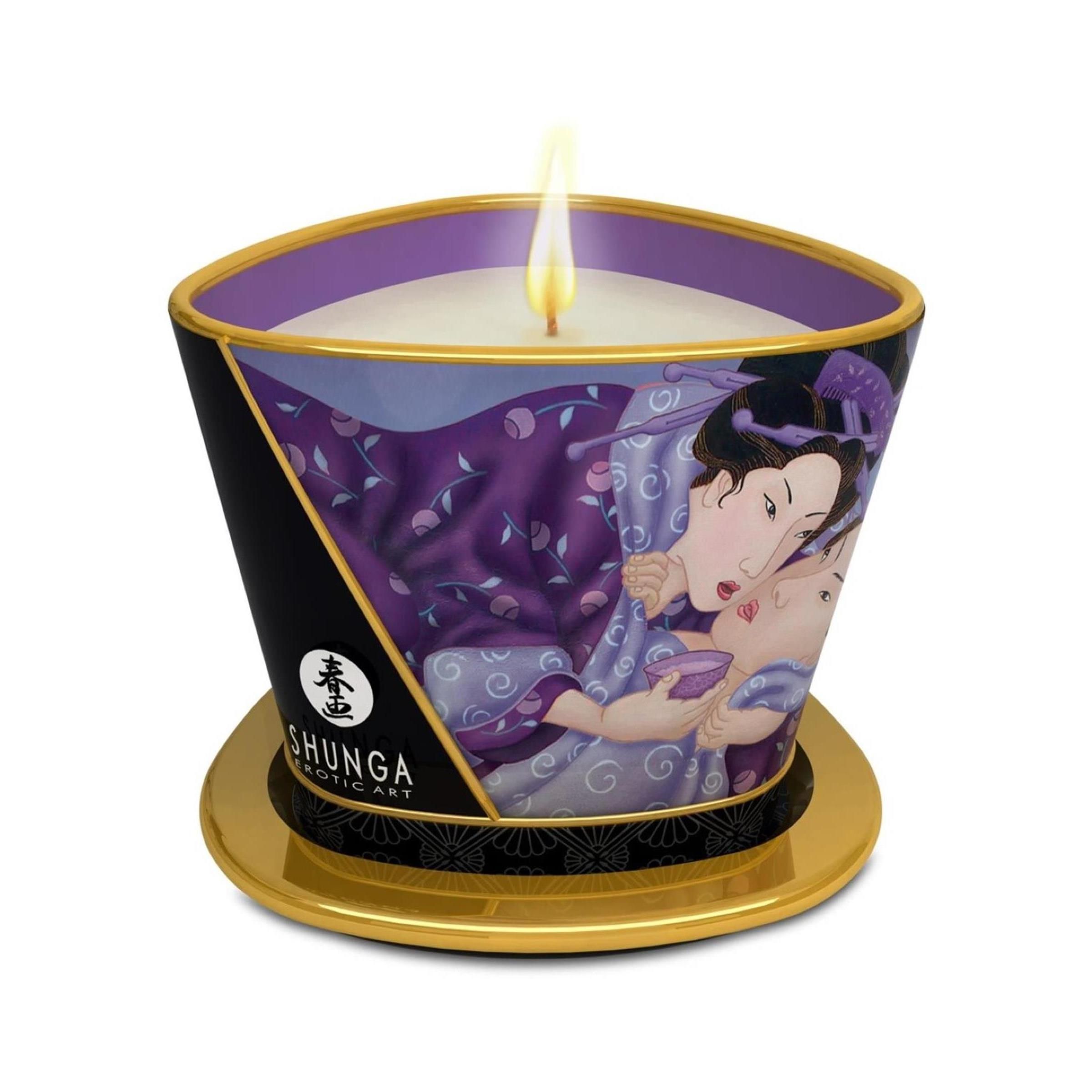 Shunga massagekaars met erotische kunst, brandend op een gouden onderzetter.
