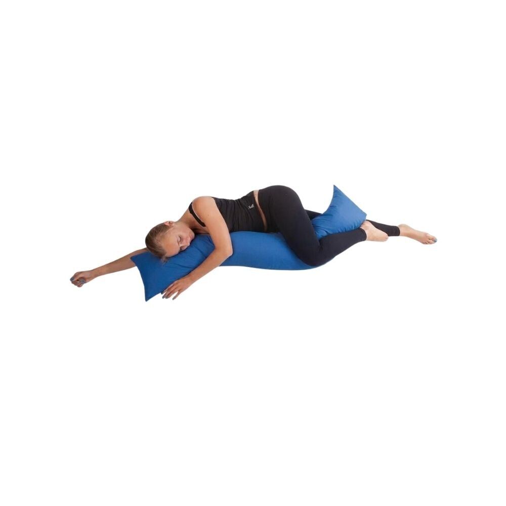 Une femme est allongée sur un coussin bleu qui soutient son corps.