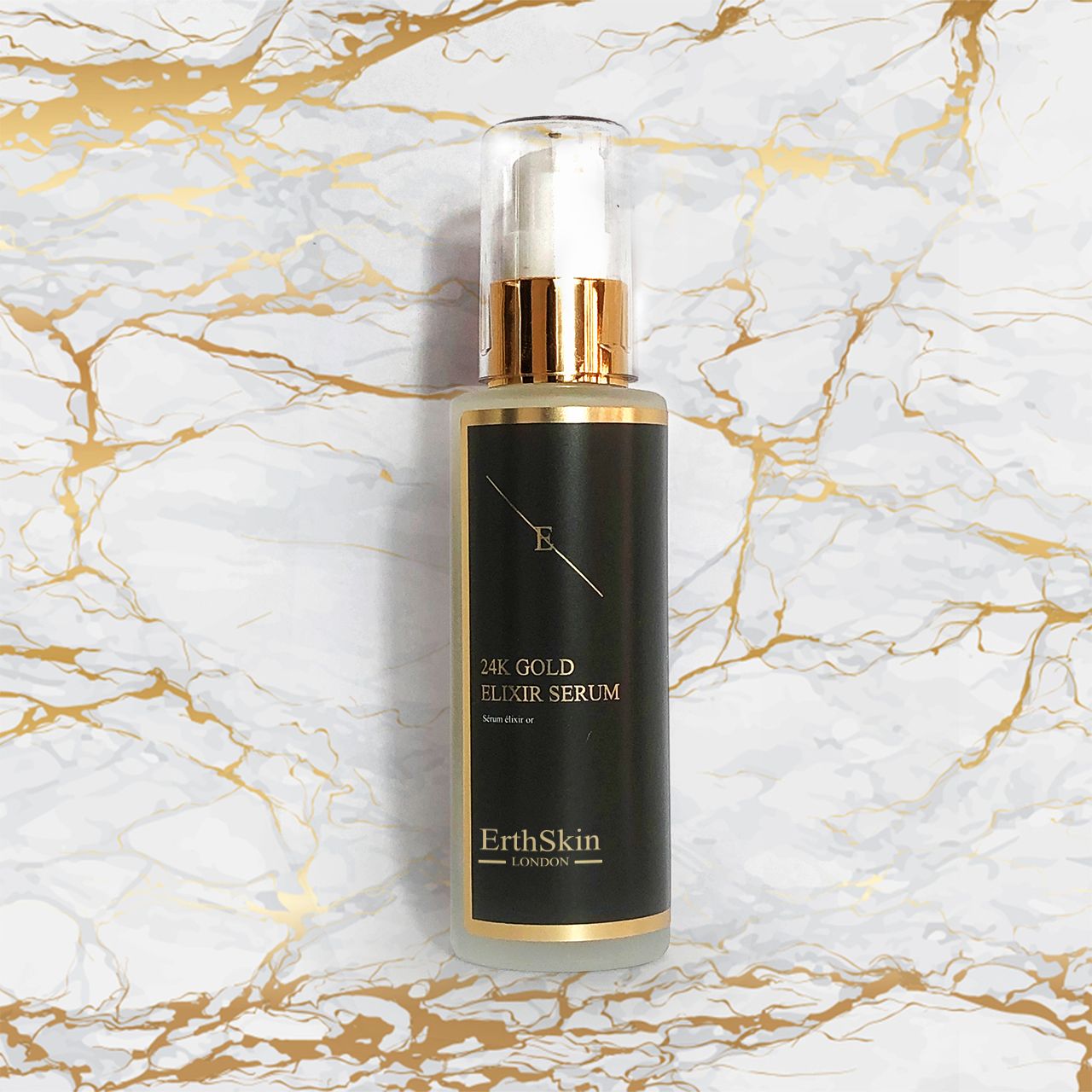 Flacon de sérum avec étiquette noire et détails dorés. Sur fond de marbre. Inscription : 24K Gold Elixir Serum.