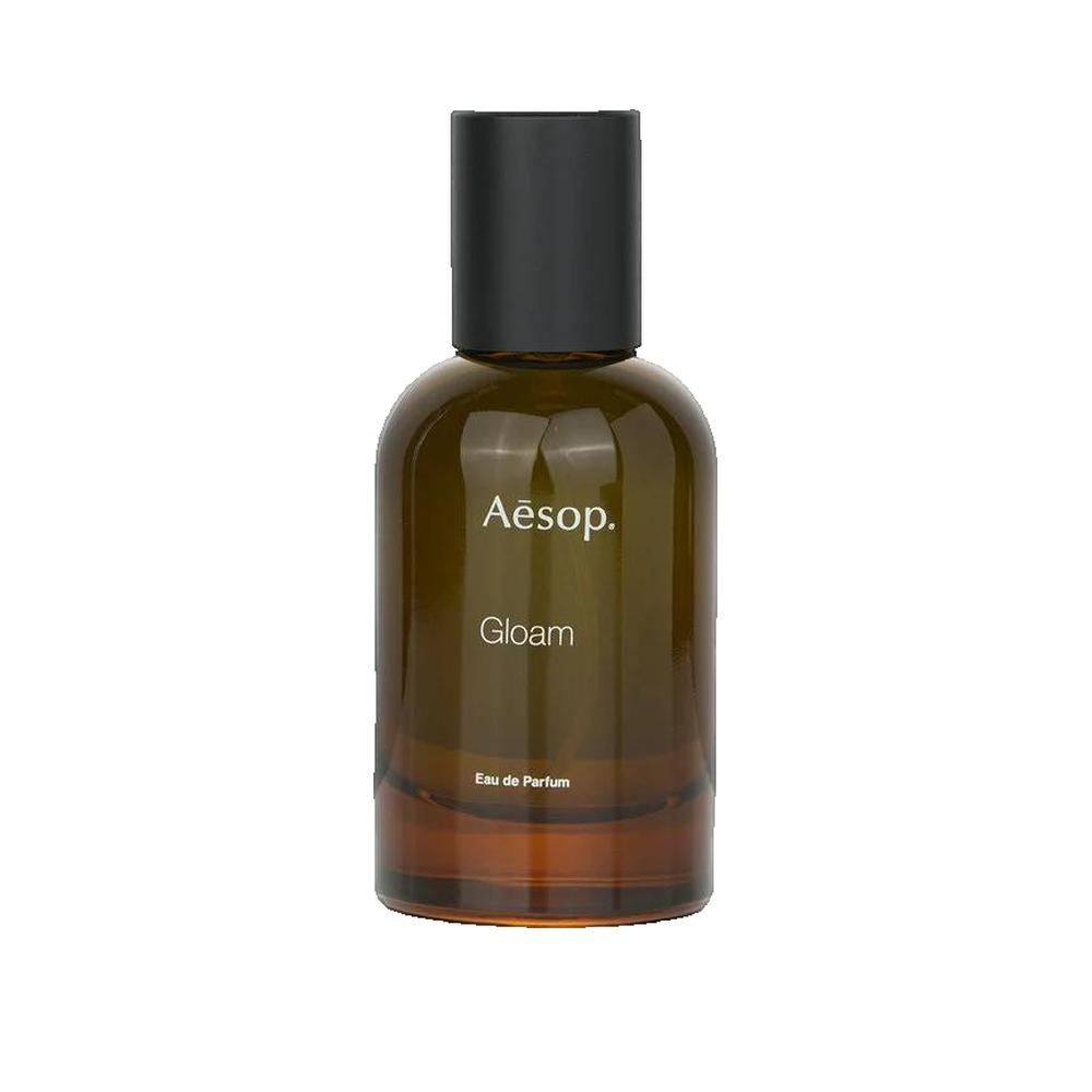 Flacon en verre brun avec bouchon noir. Logo Clarins et inscription Gloam sur l'étiquette.