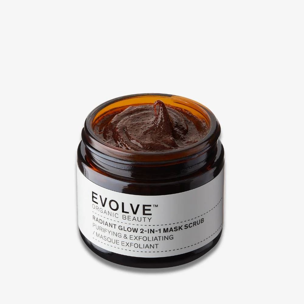 Masque facial brun dans un pot en verre brun. L'étiquette indique "EVOLVE ORGANIC BEAUTY RADIANT GLOW 2-IN-1 MASK SCRUB".
