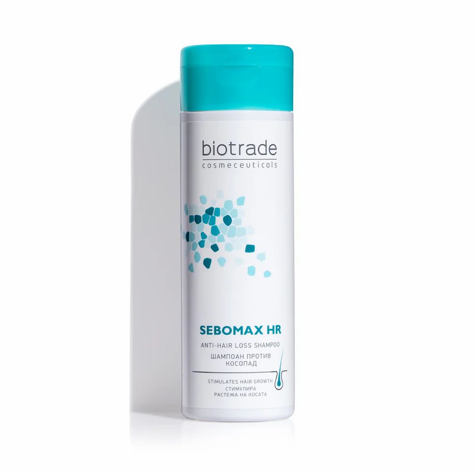 Biotrade Sebomax HR Shampoo, flacon blanc, bouchon bleu. Texte: Sebomax HR, shampooing antichute. Motifs bleus et turquoise.