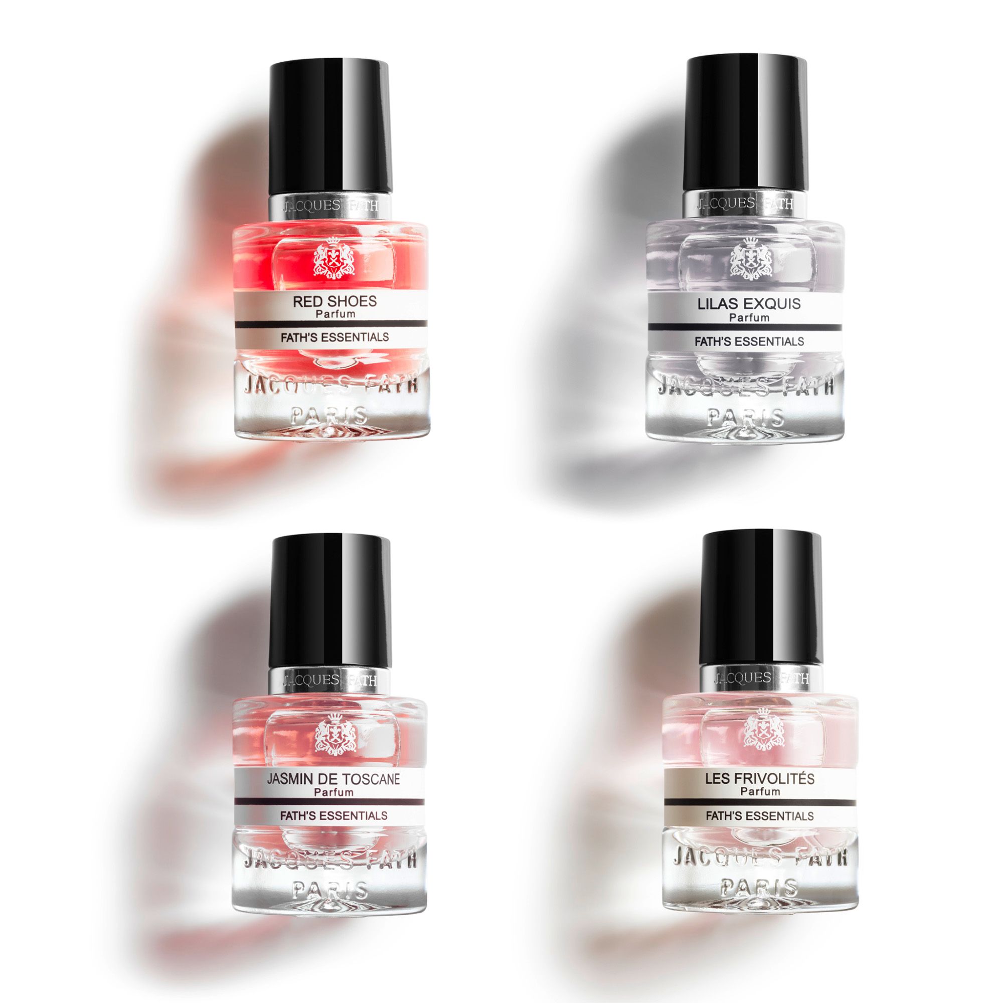 Quatre flacons de parfum miniatures avec bouchons noirs. Inscription Fath's Essentials. Différentes couleurs de liquide.