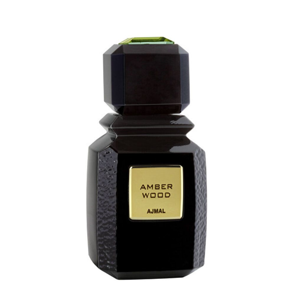 Flacon noir avec étiquette dorée AMBER WOOD et AJMAL. Bouchon angulaire avec ornement vert.