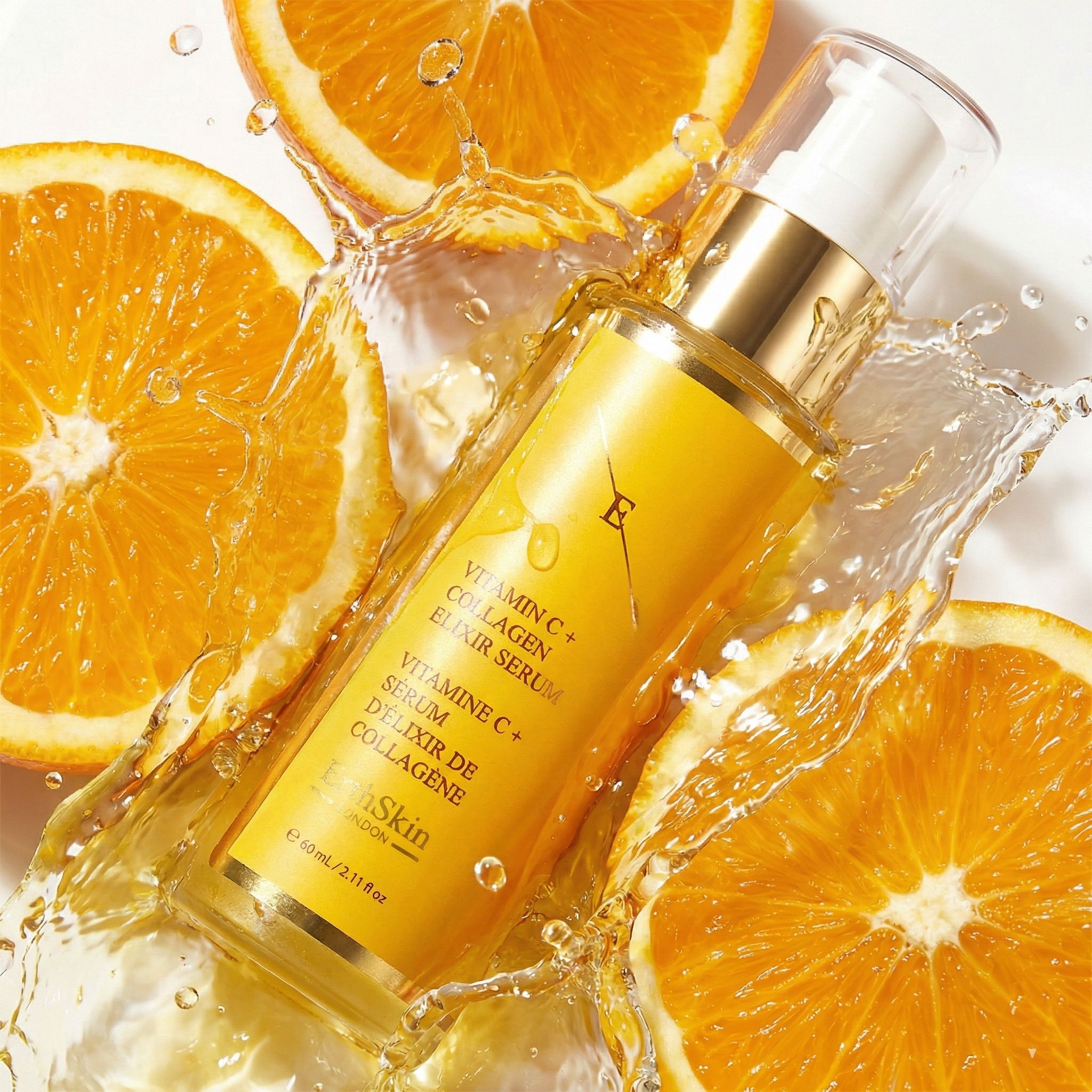 Flacon ErthSkin Vitamine C + Collagène Elixir Serum entouré d'éclaboussures d'eau et de tranches d'orange.