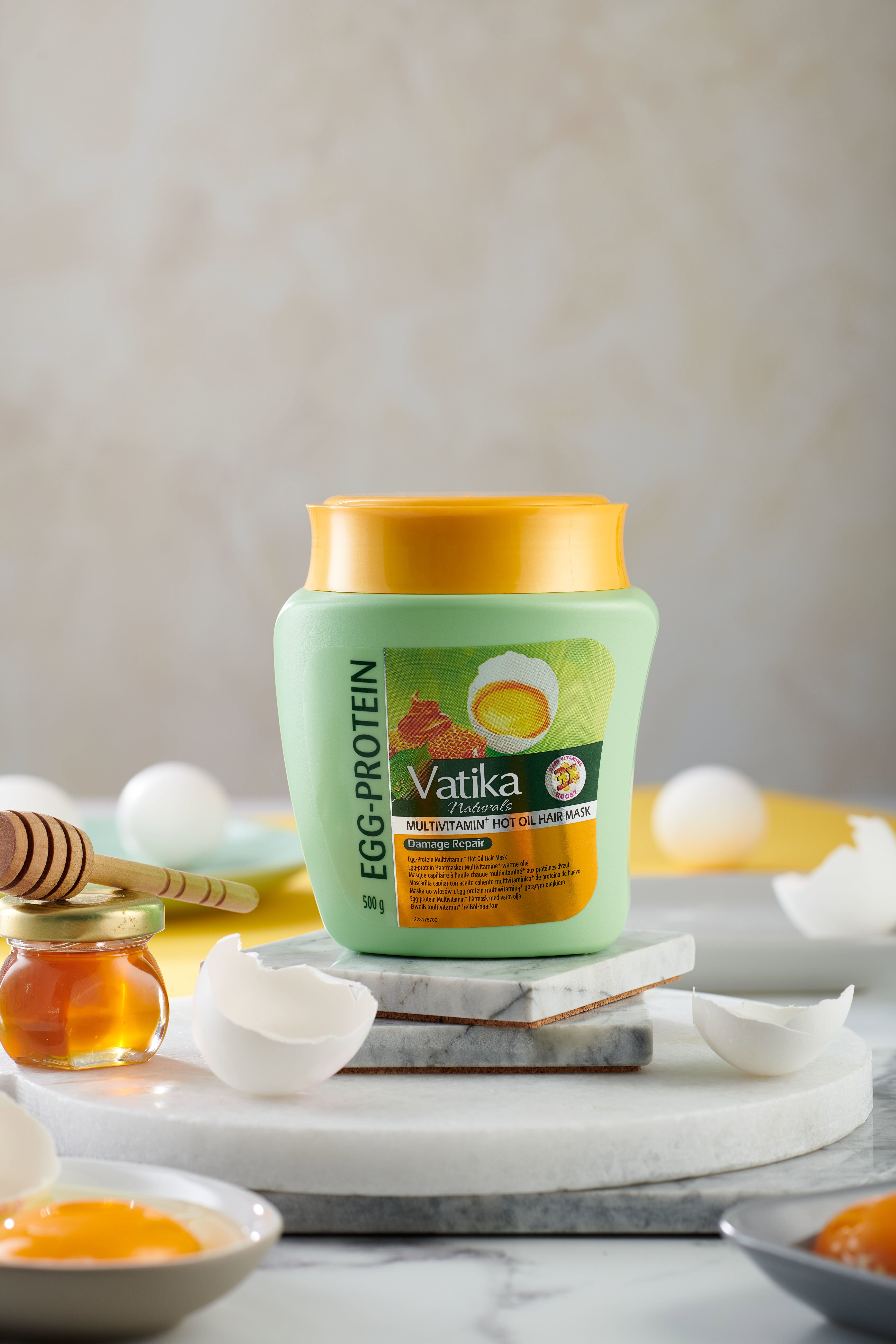 Groen haarmasker met gele deksel, honingpot, eierschalen. Tekst: Vatika Naturals, Egg-Protein, Multivitamin, Hot Oil Hair Mask, 500g.
