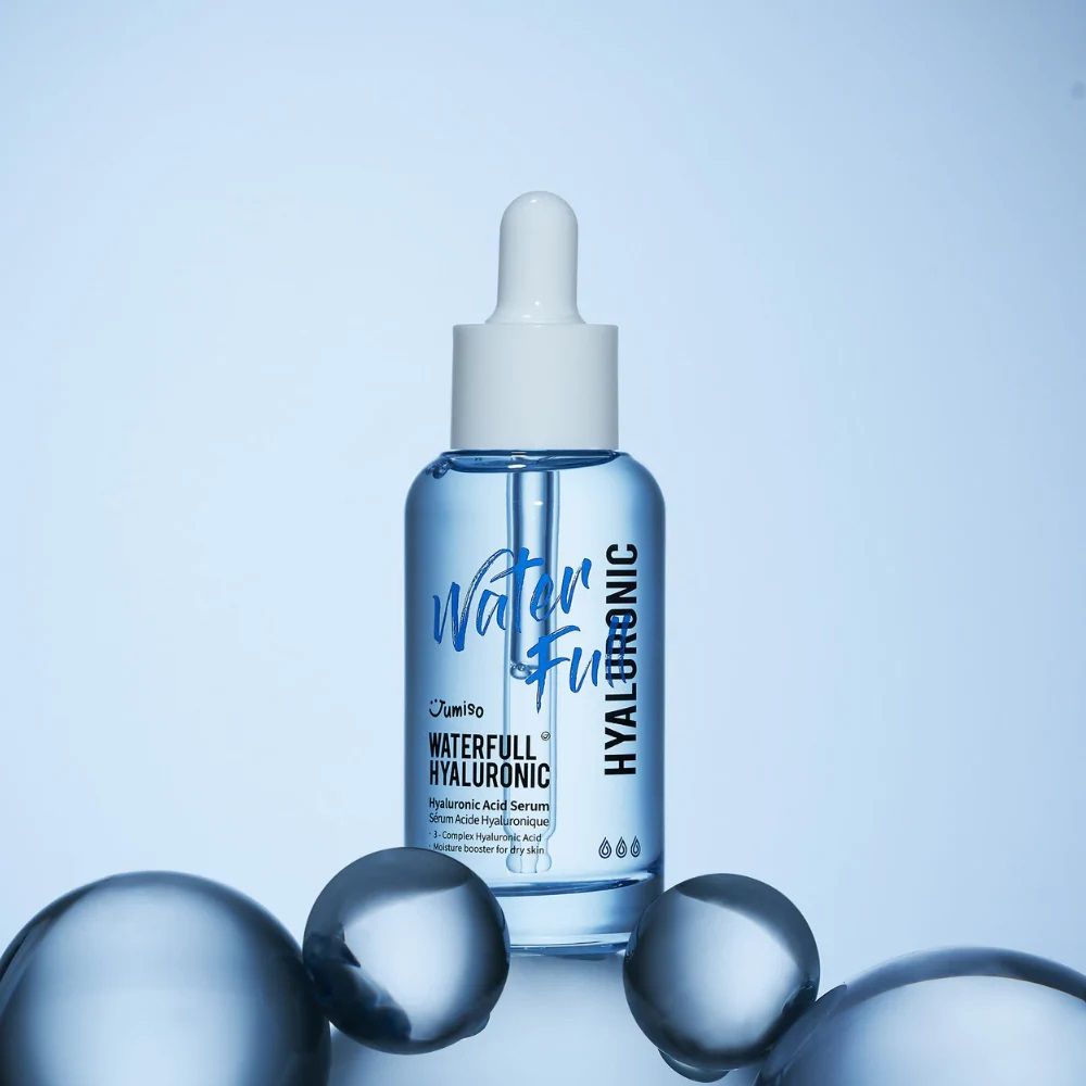 Blauw serumflesje met witte dop en pipet, omringd door blauwe bollen. Opschrift: Waterfull Hyaluronic.