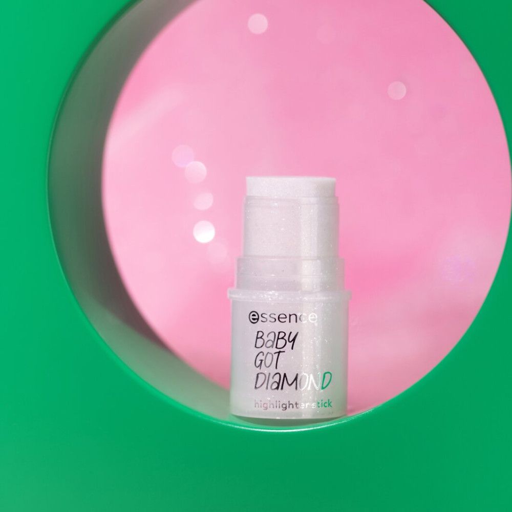 Stick illuminateur dans un cercle vert sur fond rose. Inscription: Essence, Baby Got Diamond, Highlighter Stick.
