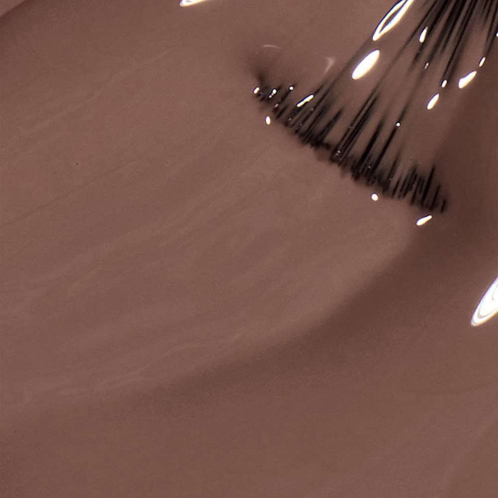 Nagellak applicator in bruine nagellak. Kwastje met lak. Close-up.