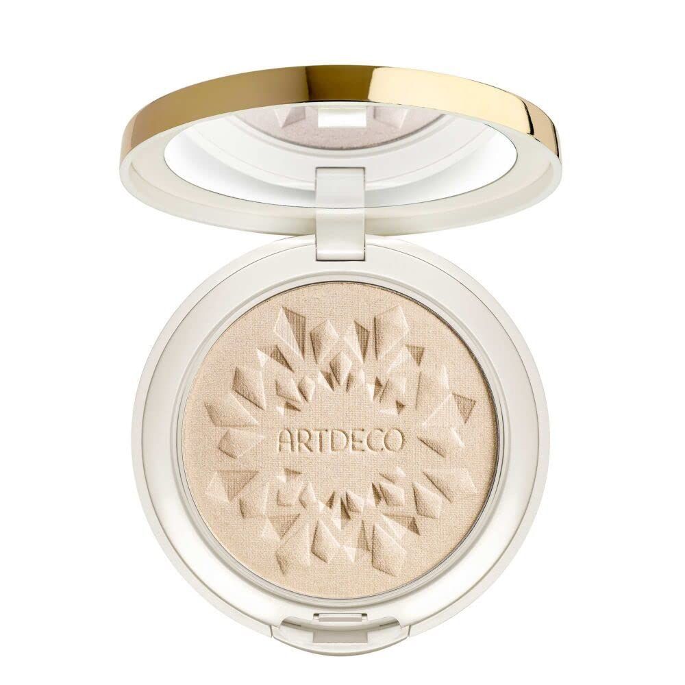 Ronde witte compactpoeder met gouden rand en deksel. Binnenin spiegel en poeder met logo. Productnaam: Artdeco.