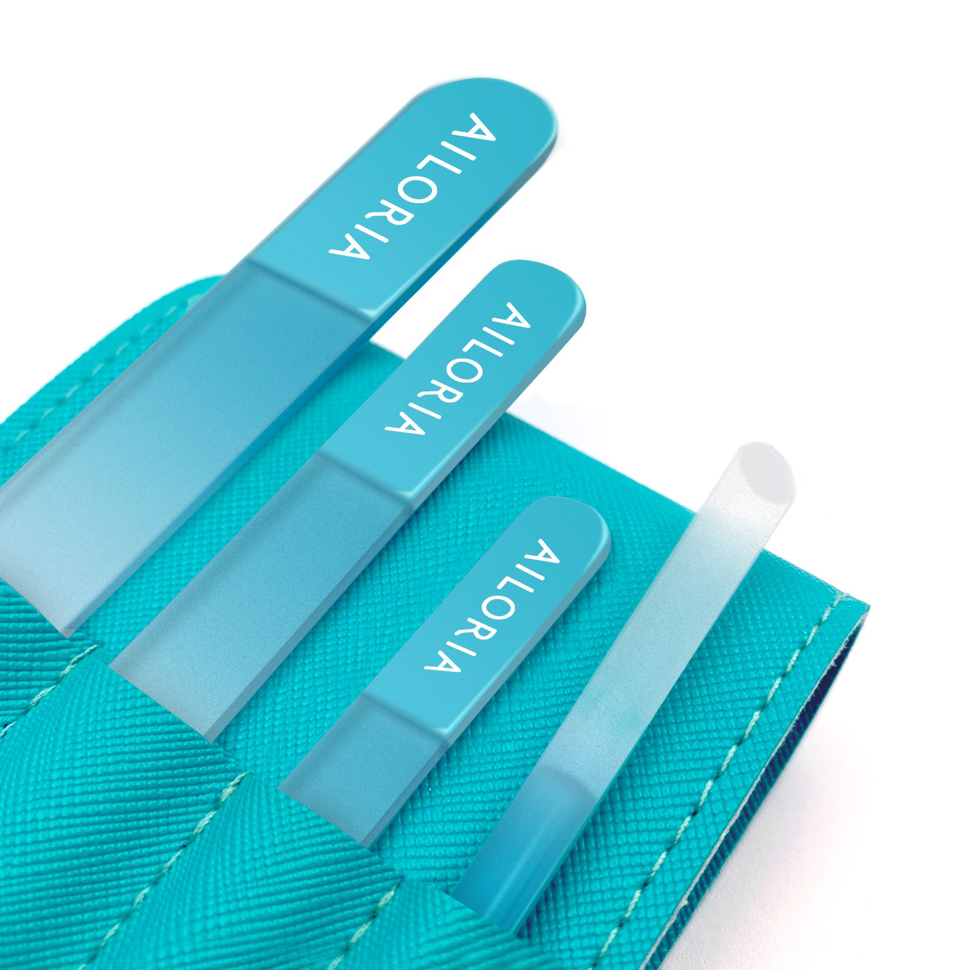 Gros plan de trois limes à ongles en verre dans un étui turquoise. Les limes portent le nom de marque AILORIA.