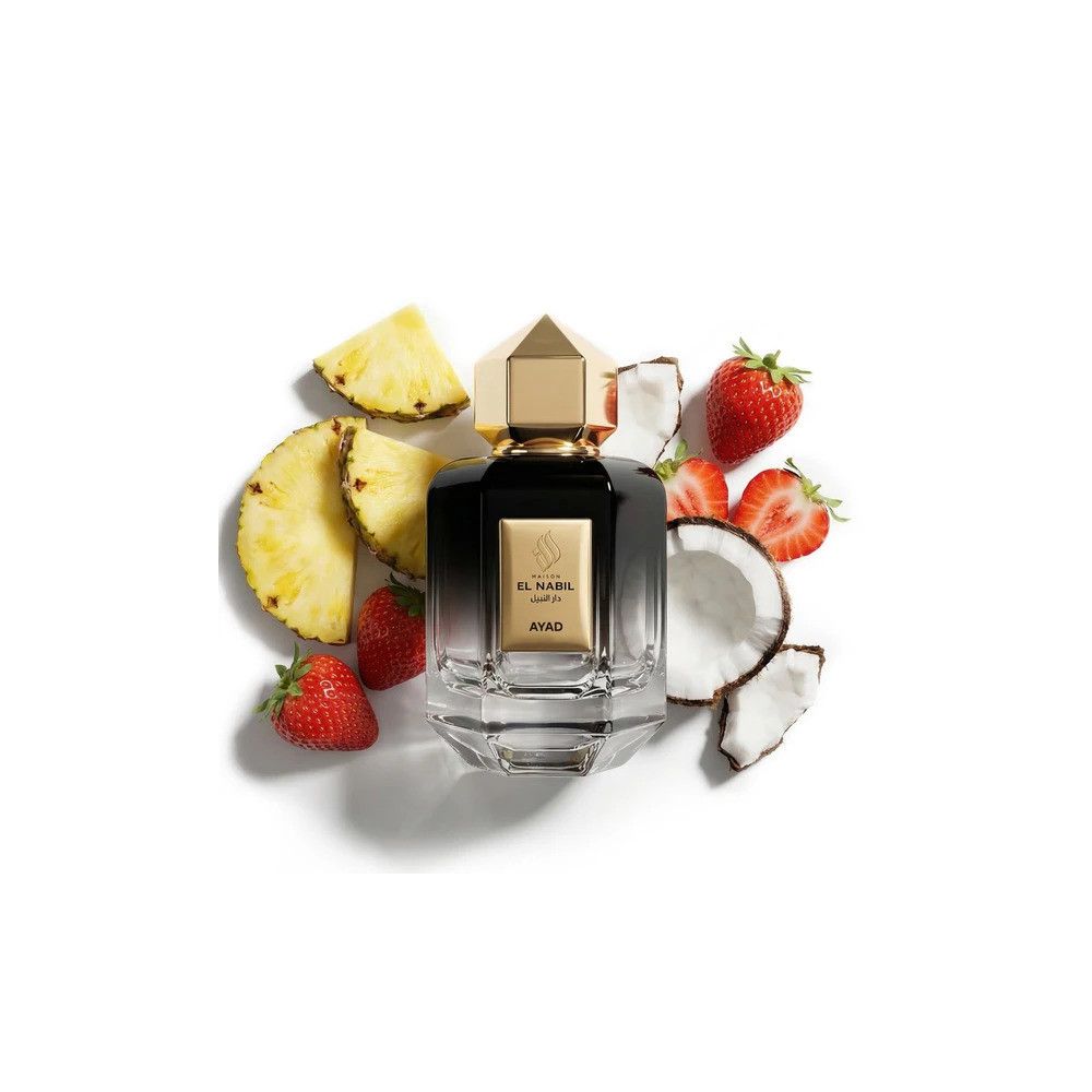 Flacon de parfum en verre noir avec bouchon doré, entouré de tranches d'ananas, de fraises et de noix de coco.