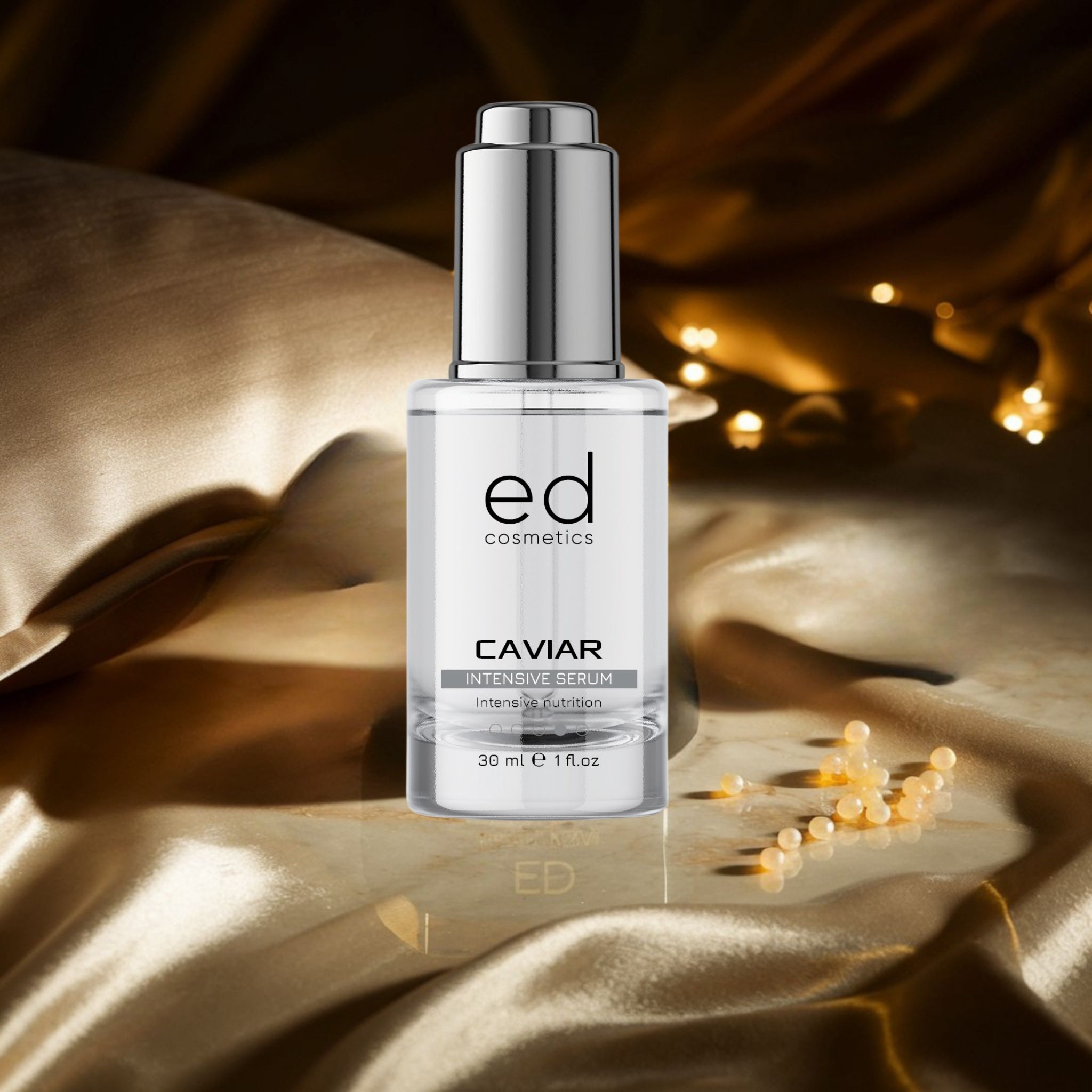 Flacon de sérum avec bouchon argenté. Inscription : "ed cosmetics", "CAVIAR INTENSIVE SERUM". Sur tissu doré.