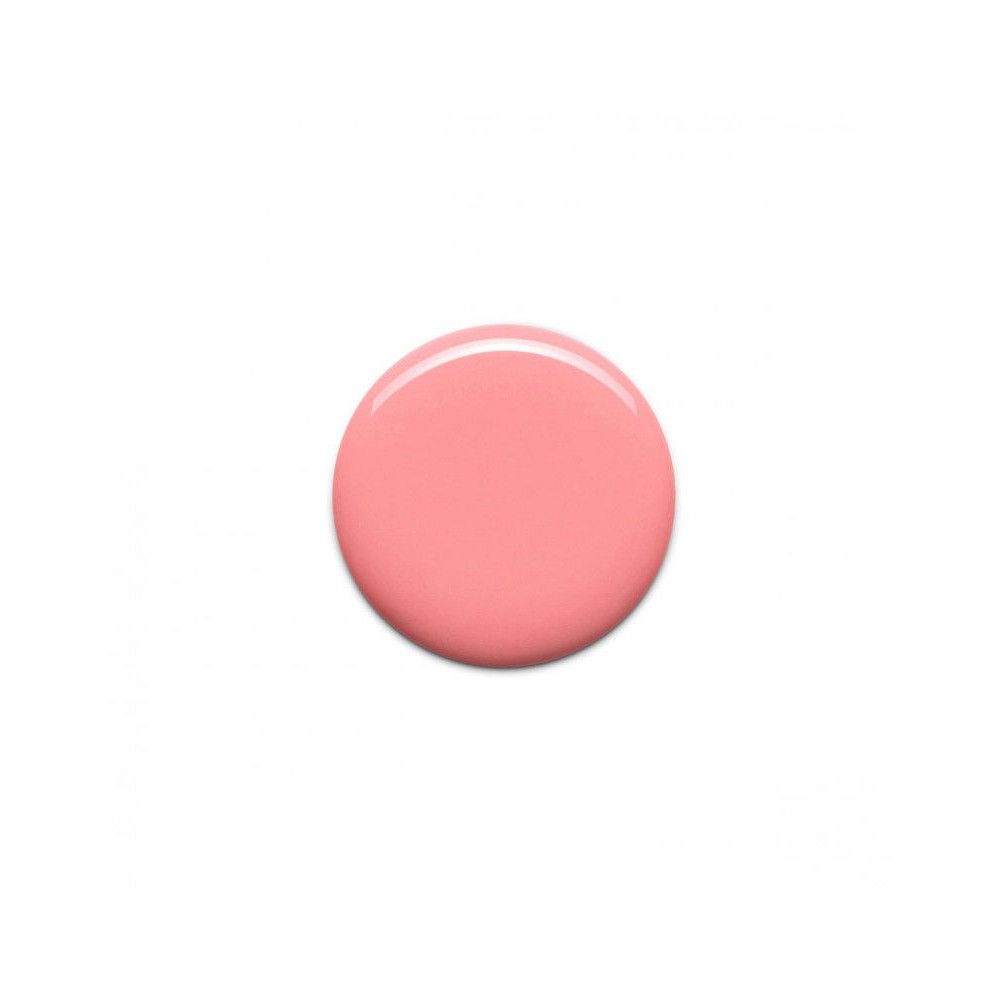 Tache ronde de vernis à ongles rose sur fond blanc.