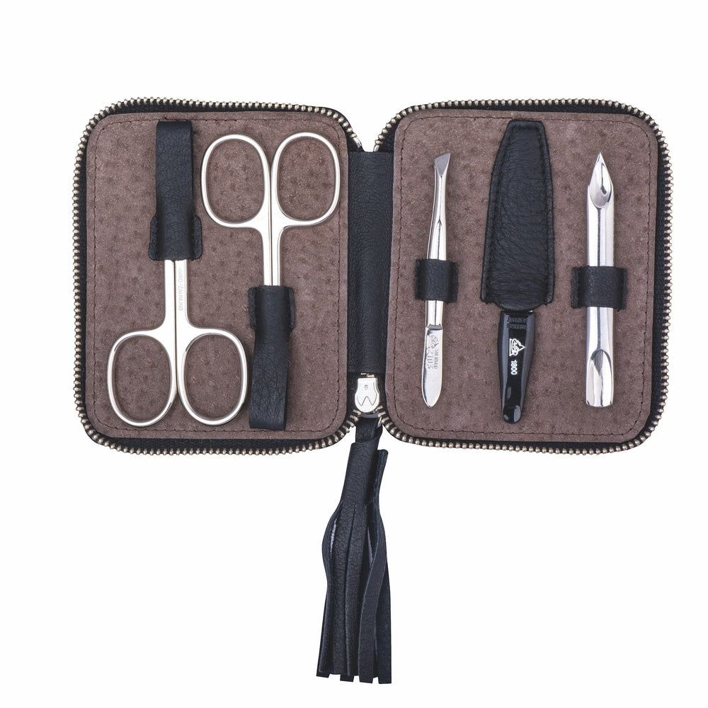Trousse de manucure noire ouverte, marron. Ciseaux, pince à épiler, lime à ongles et coupe-ongles. Fermeture éclair.
