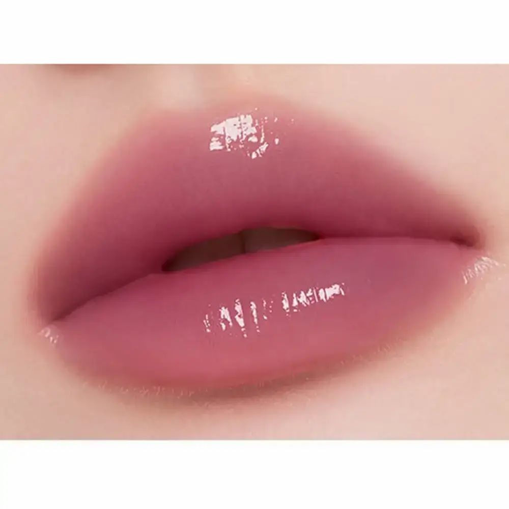 Close-up van lippen bedekt met een glanzend, roze lipproduct. De lippen zijn glanzend en reflecteren het licht.