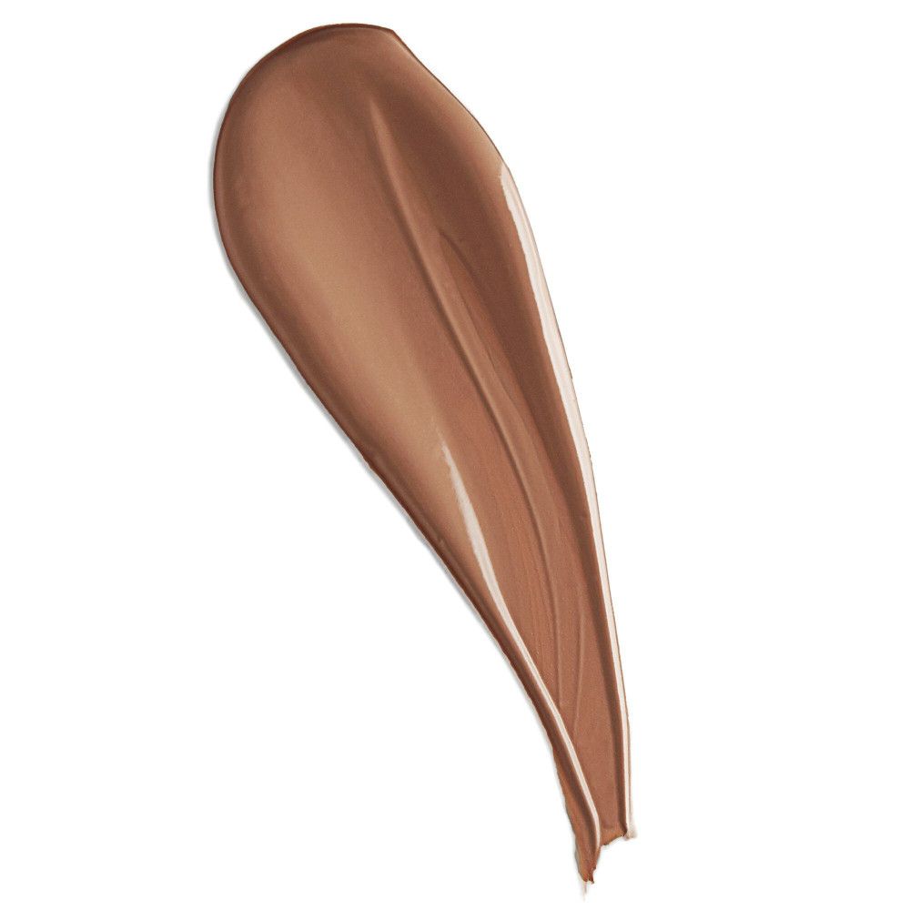 Échantillon de correcteur étalé, couleur marron clair. Texture brillante, sur fond blanc.