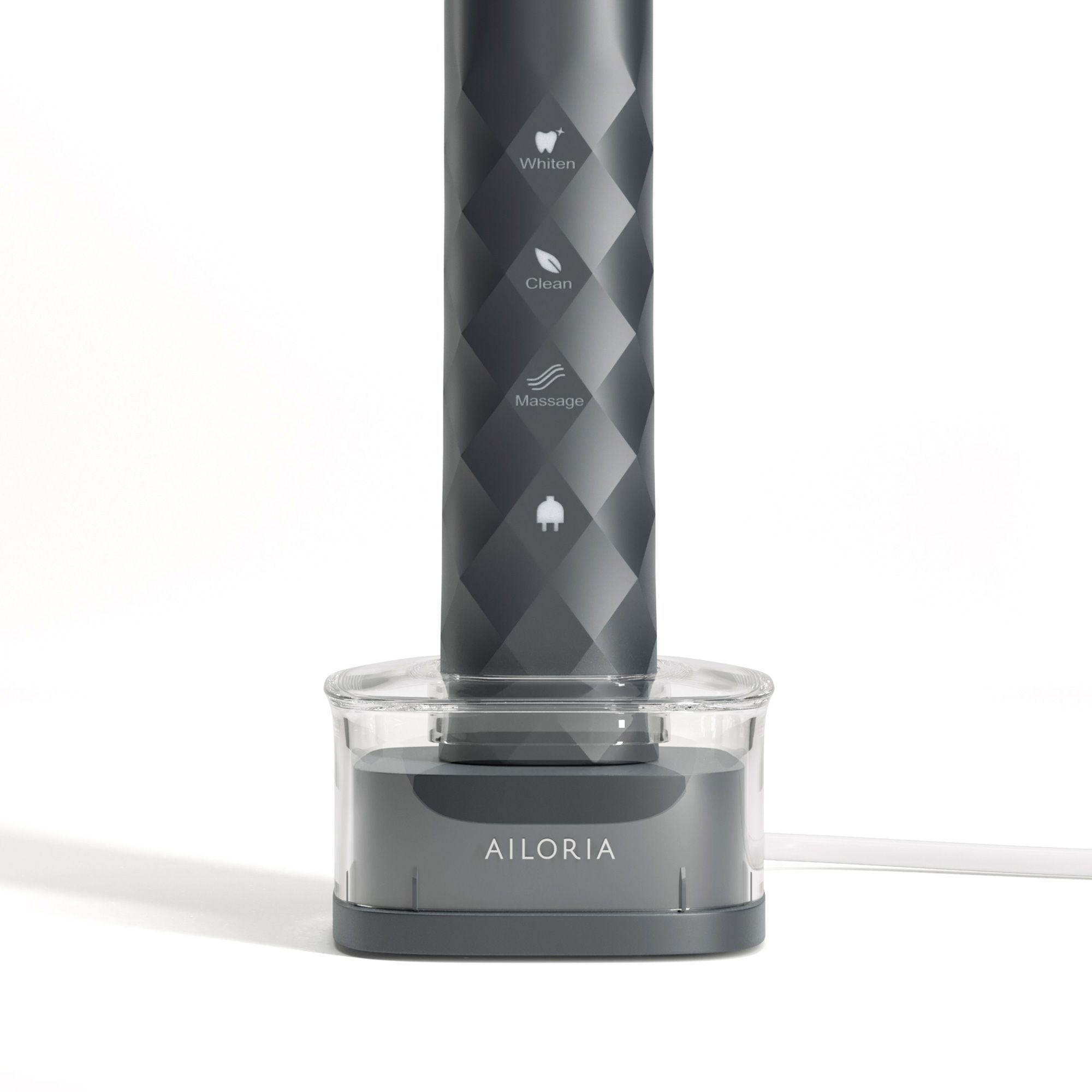 Inductief laadstation met tandenborstel. Grijze behuizing met transparante houder. AILORIA-opschrift.